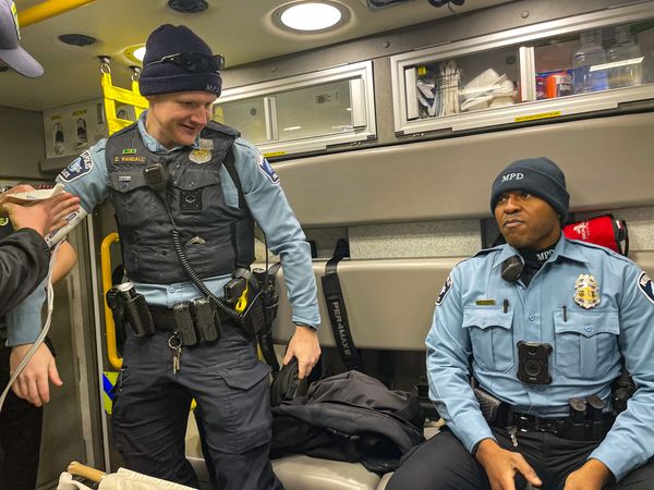 Officer Jamal Mitchell, right, with Officer Zachery Randall after helping an elderly couple from a burning house in February 2023