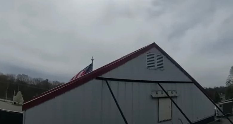 Moment police confront woman living in grocery store roof sign