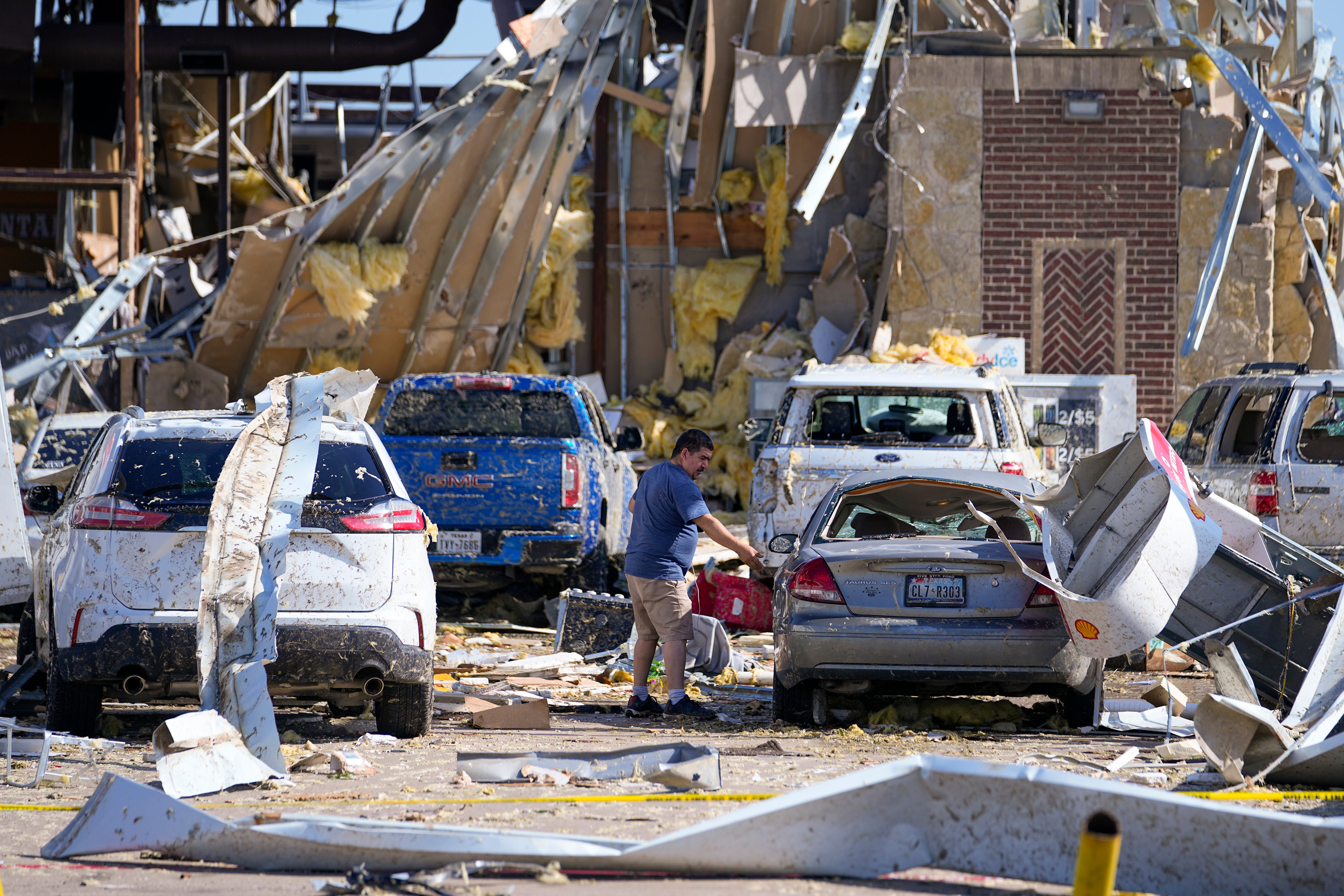 Damaged cars and buildings after a tornado hit the day before, Sunday, May 26, 2024, in Valley View, Texas