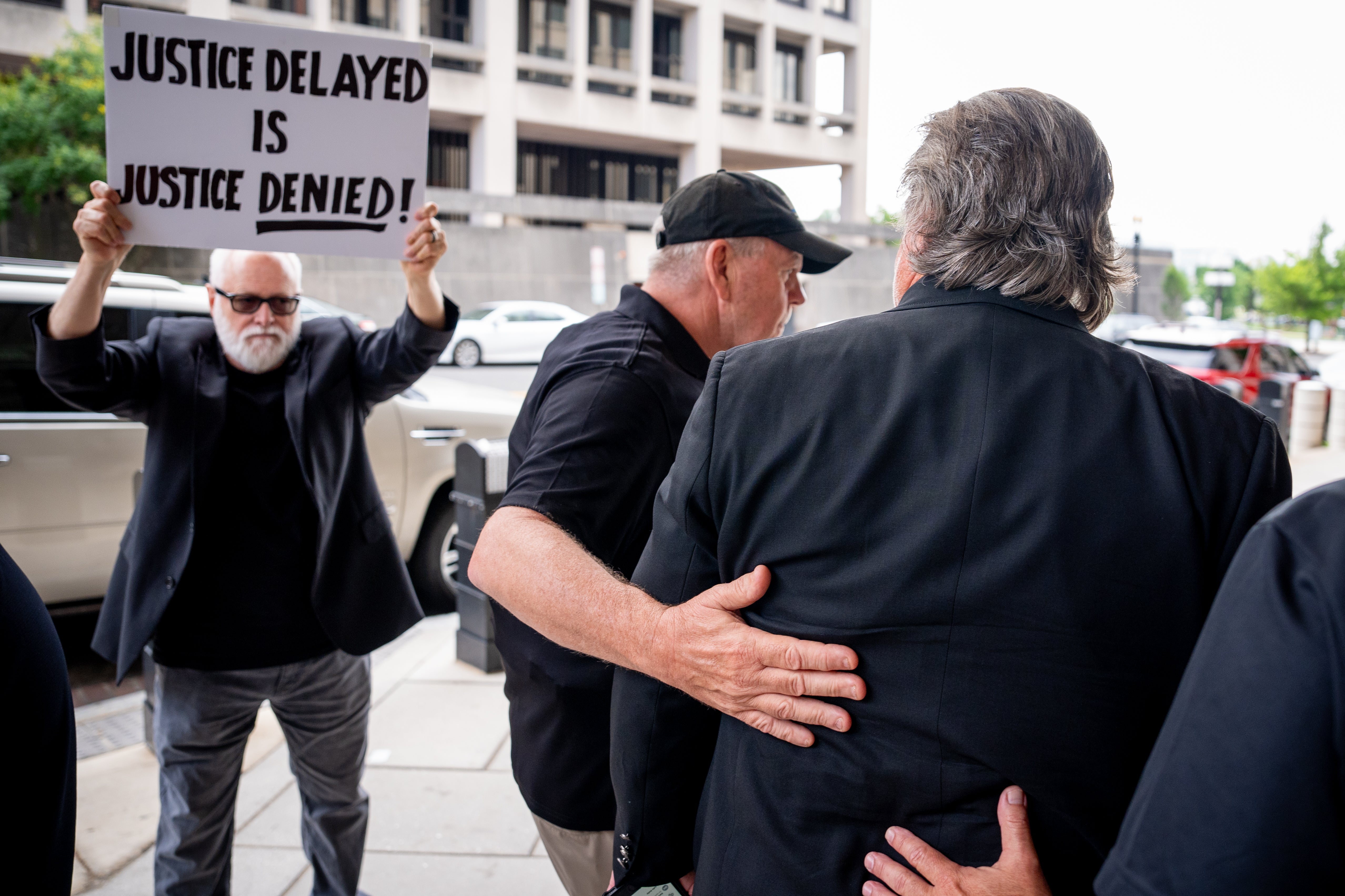 A protester greets Steve Bannon as he arrives at a federal courthouse in Washington DC for setencing on June 6.