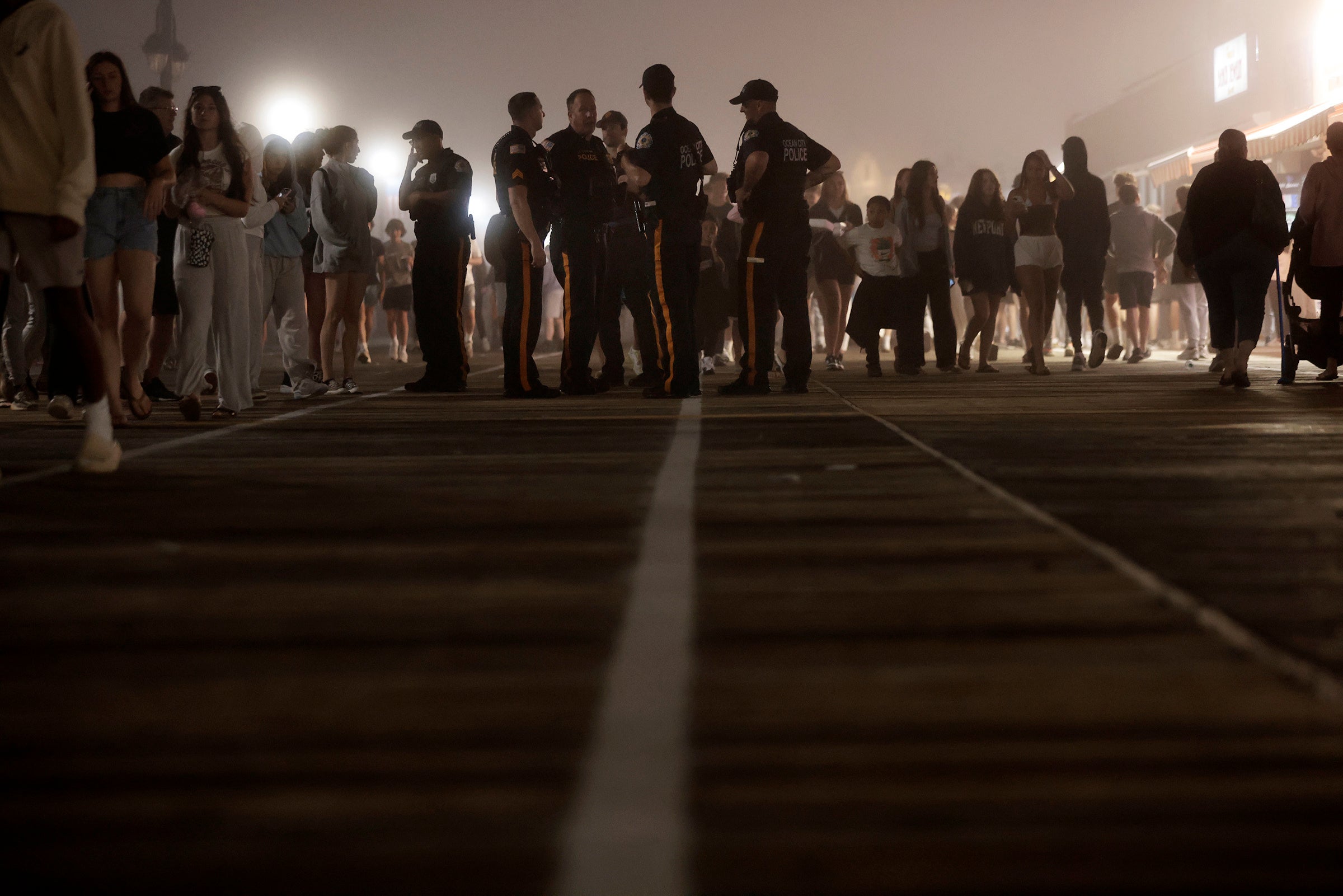 Police watch the crowds on the boardwalk in Ocean City, N.J., on Memorial Day weekend, Sunday, May 26, 2024