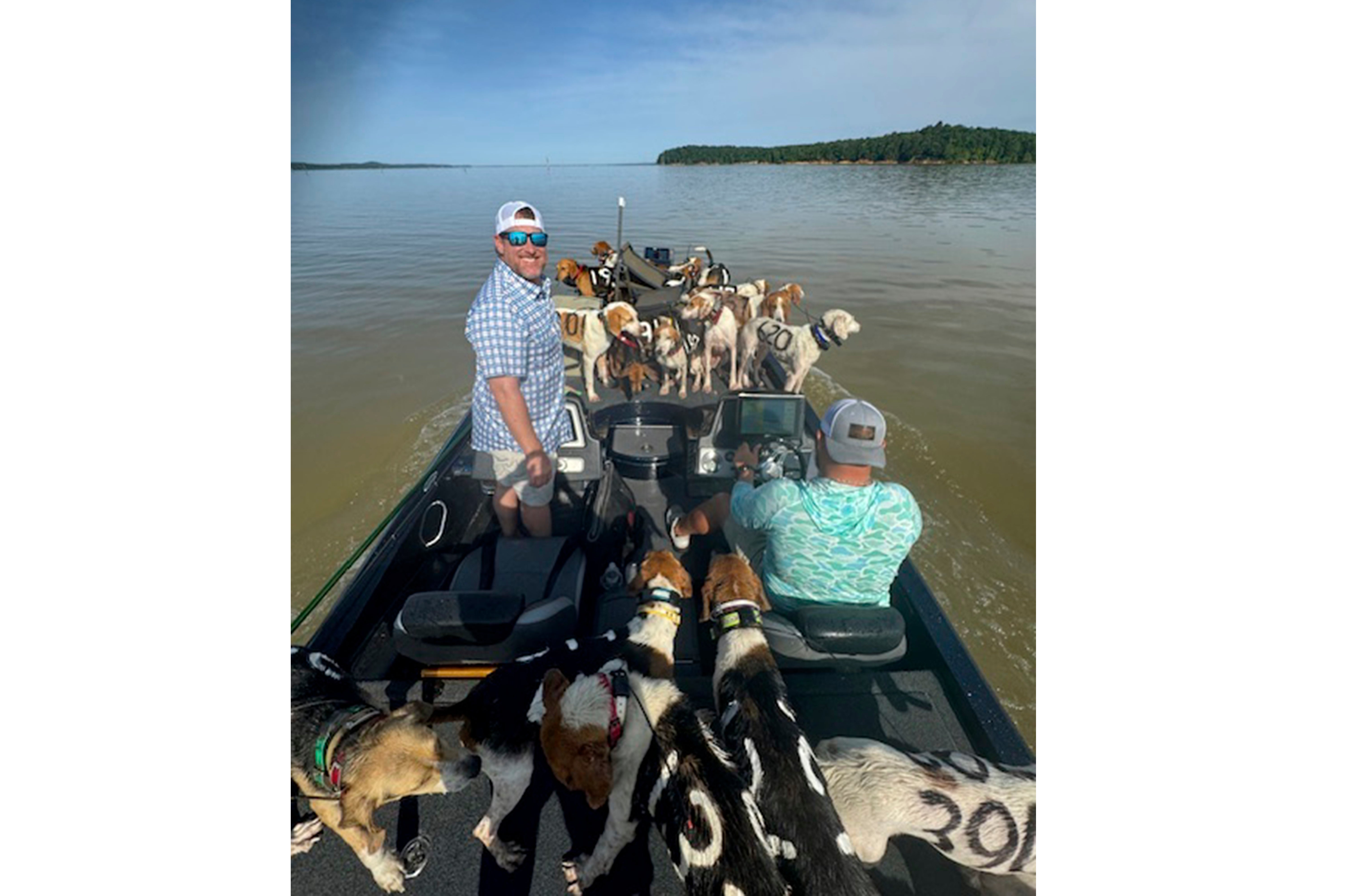 Fisherman Brad Carlisle, left, and fishing guide Jordan Chrestman bring one of three boatloads of dogs back to shore after they were found struggling to stay above water far out in Mississippi’s Grenada Lake