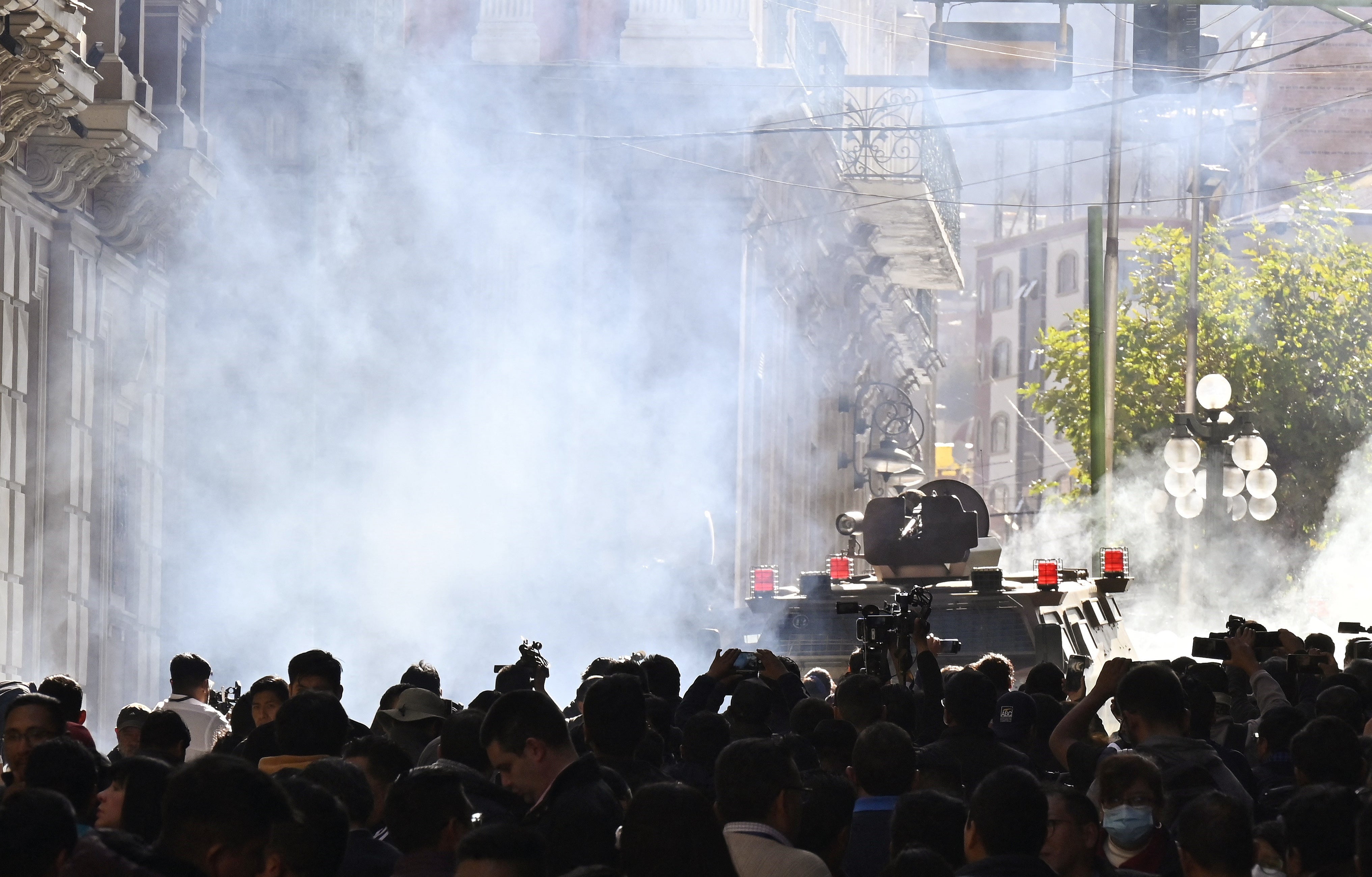 Military troops in armoured vehicles fire teargas at crowds outside the Quemado Palace at Plaza Murillo in La Paz