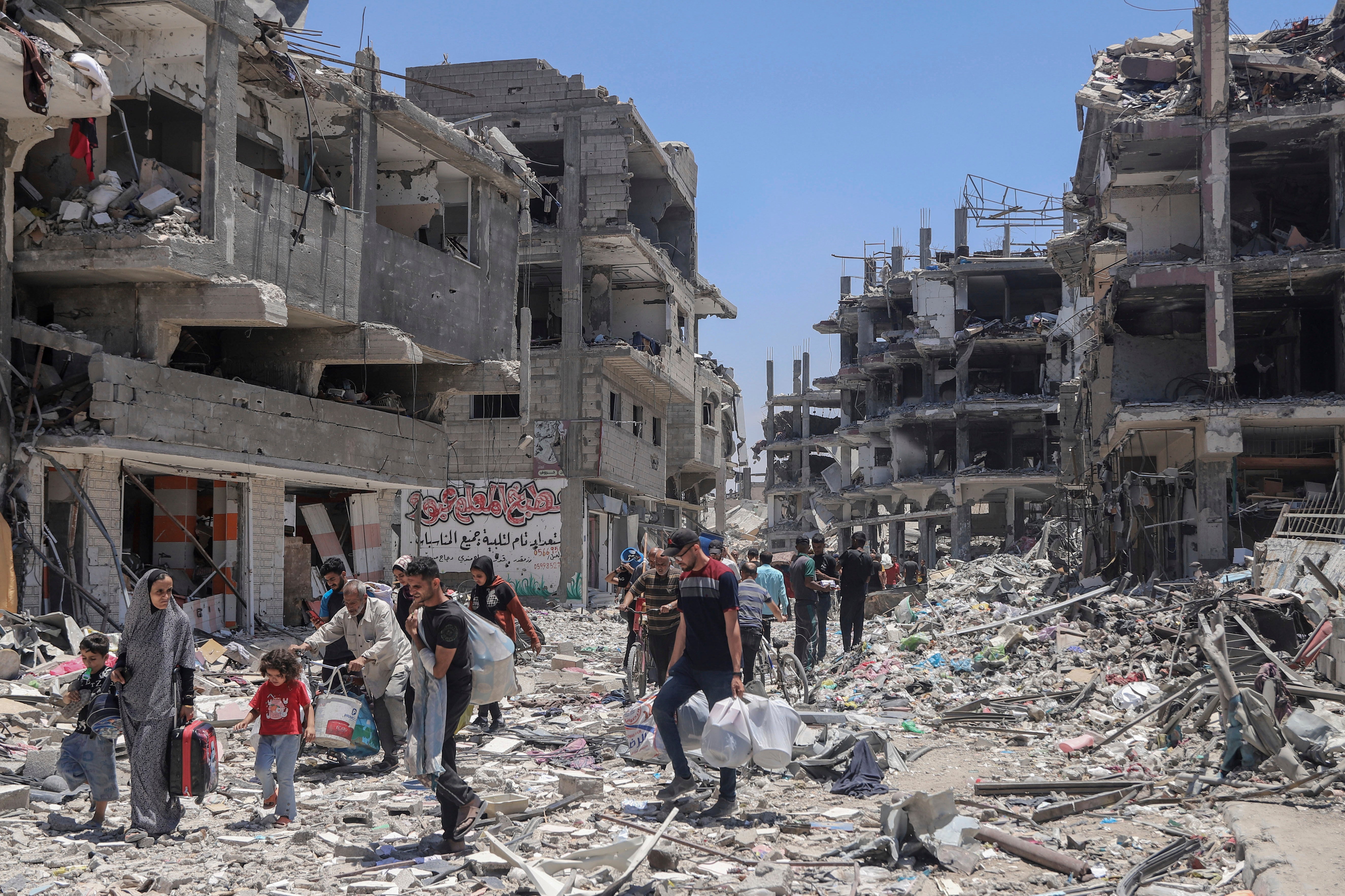 Palestinians walk through the destruction in the wake of an Israeli air and ground offensive in Jebaliya, northern Gaza Strip,