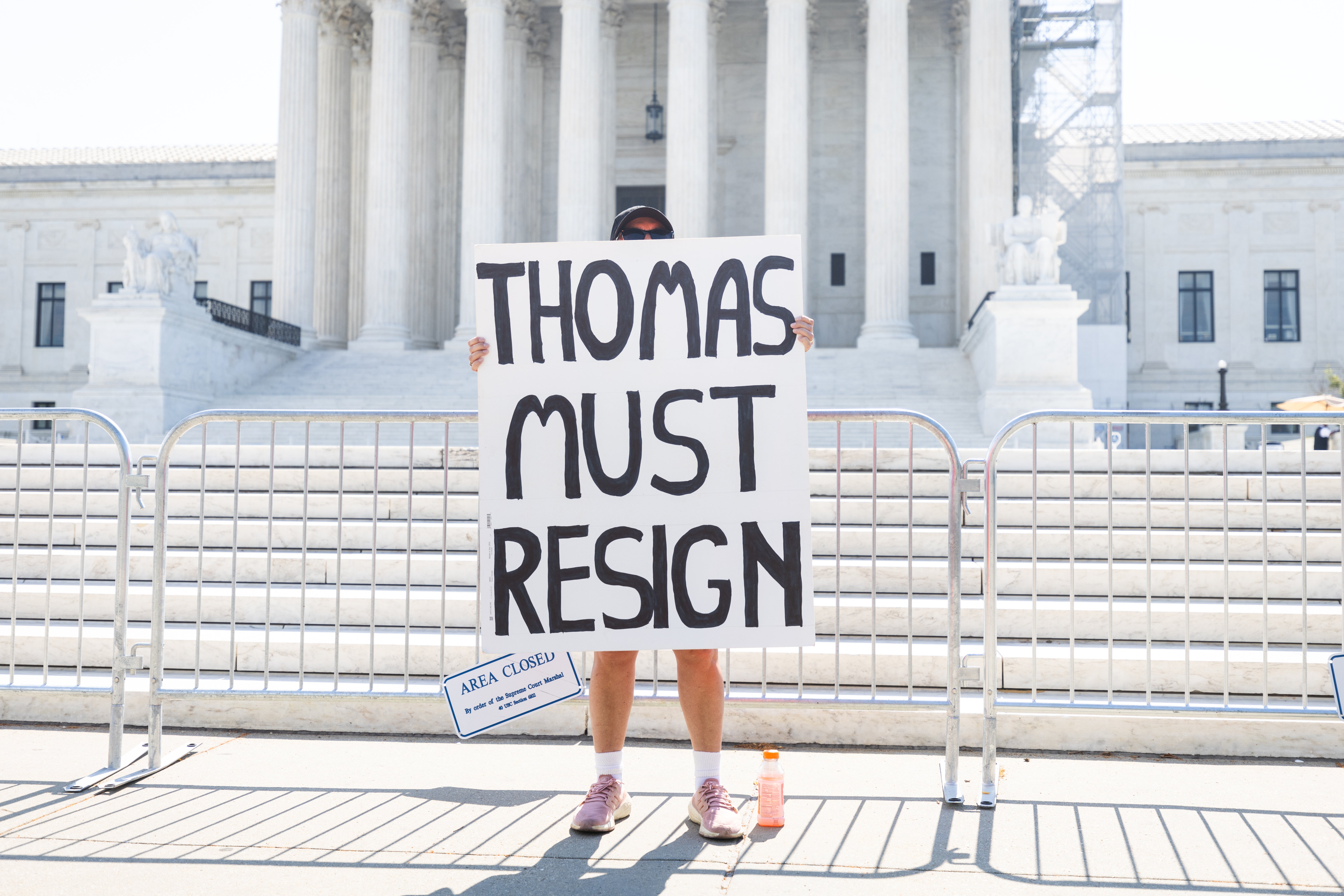 A lone protester holds a sign calling on Supreme Court Justice Clarence Thomas to resign. Reports have detailed how Thomas got millions in gifts during his time on the bench.