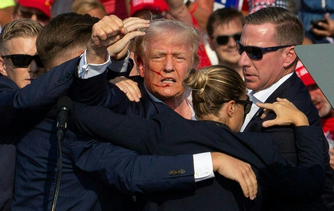 Republican candidate Donald Trump is seen with blood on his face surrounded by Secret Service agents as he is taken off the stage at a campaign event in Butler, Pennsylvania