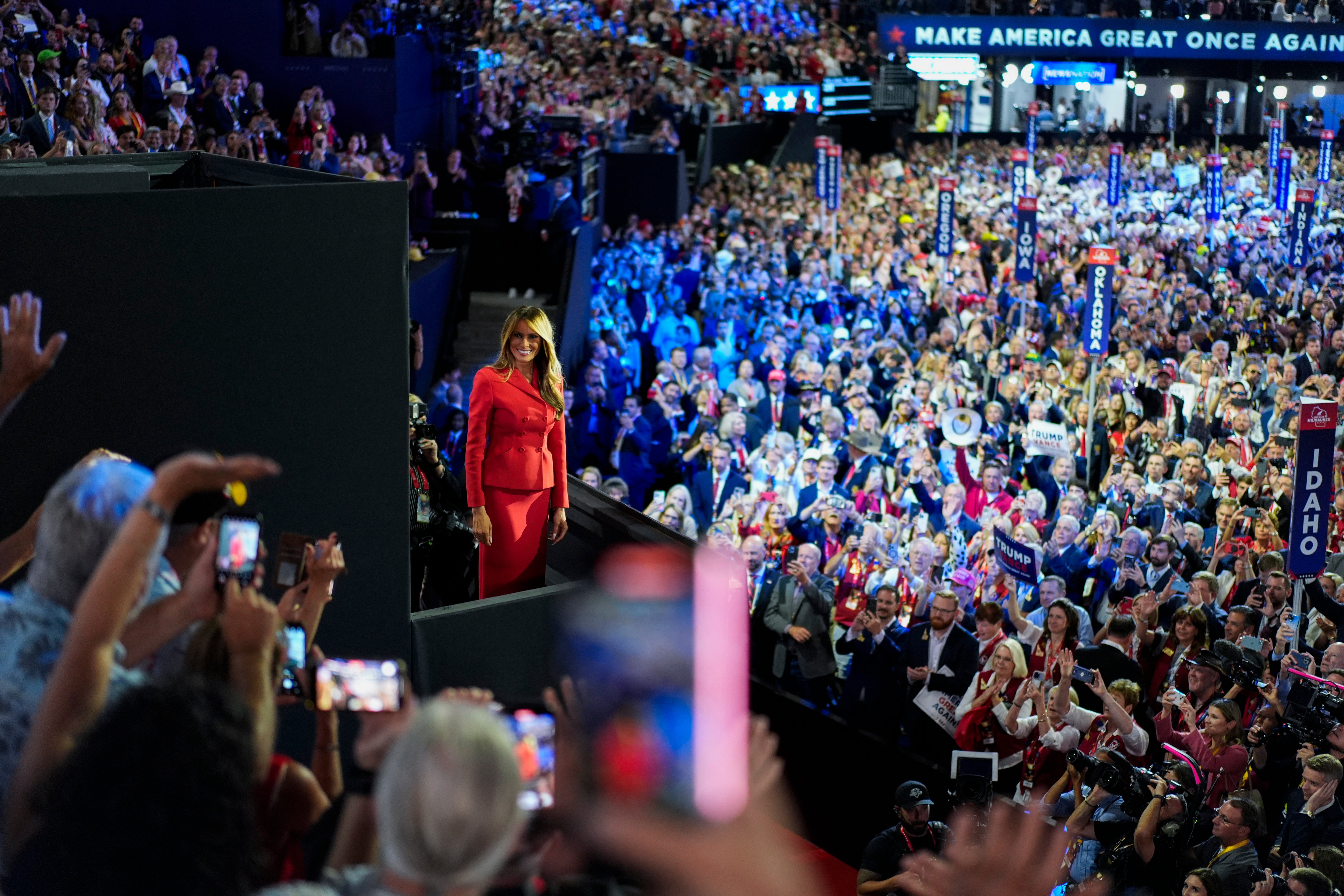 Wearing a red suit, Melania smiled and waved to supporters, before joing her husband and JD Vance in the box