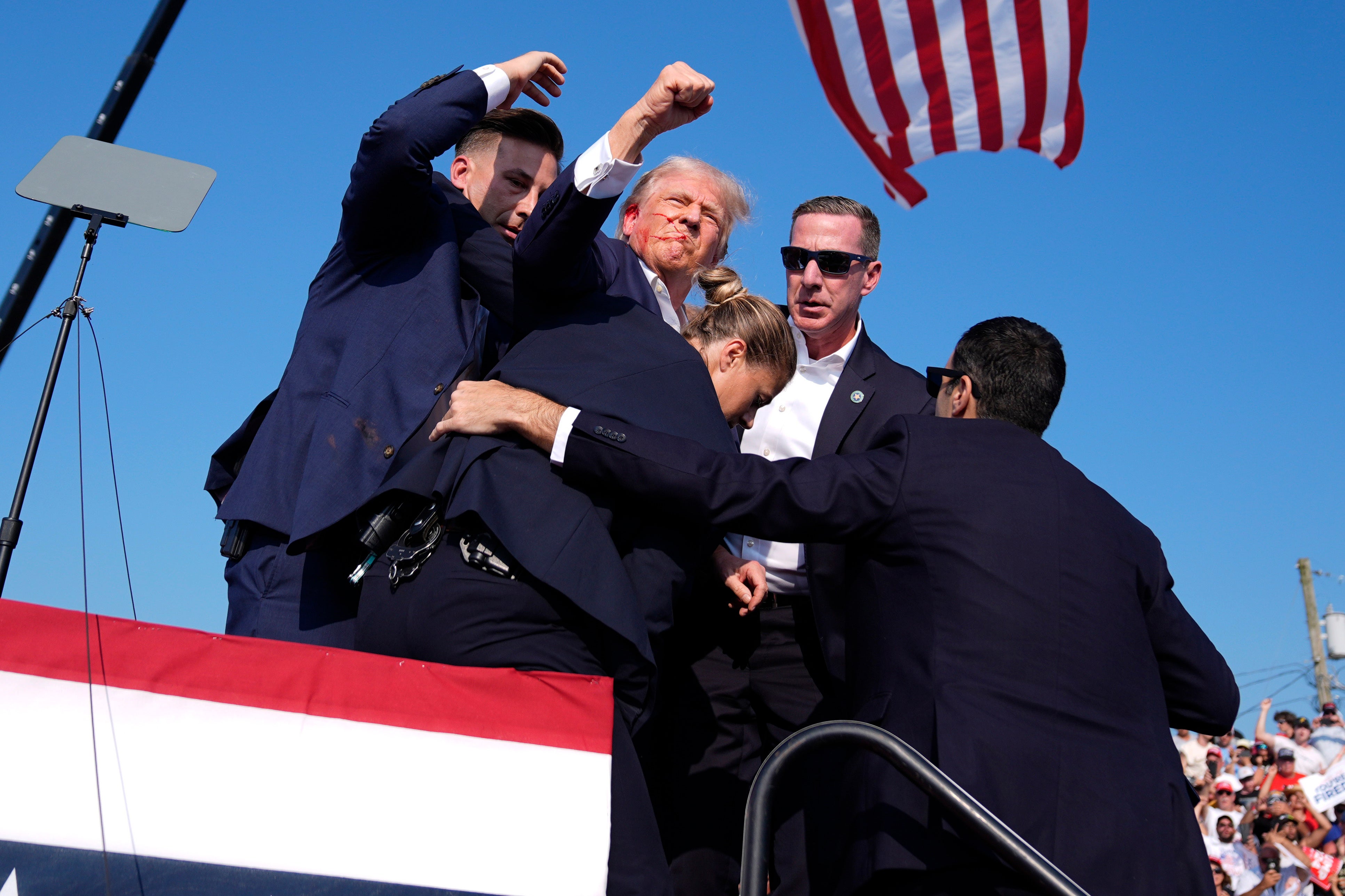 US Secret Service agents surround Donald Trump at a campaign rally on Saturday, July 13, 2024, shortly after loud popping noises erupted