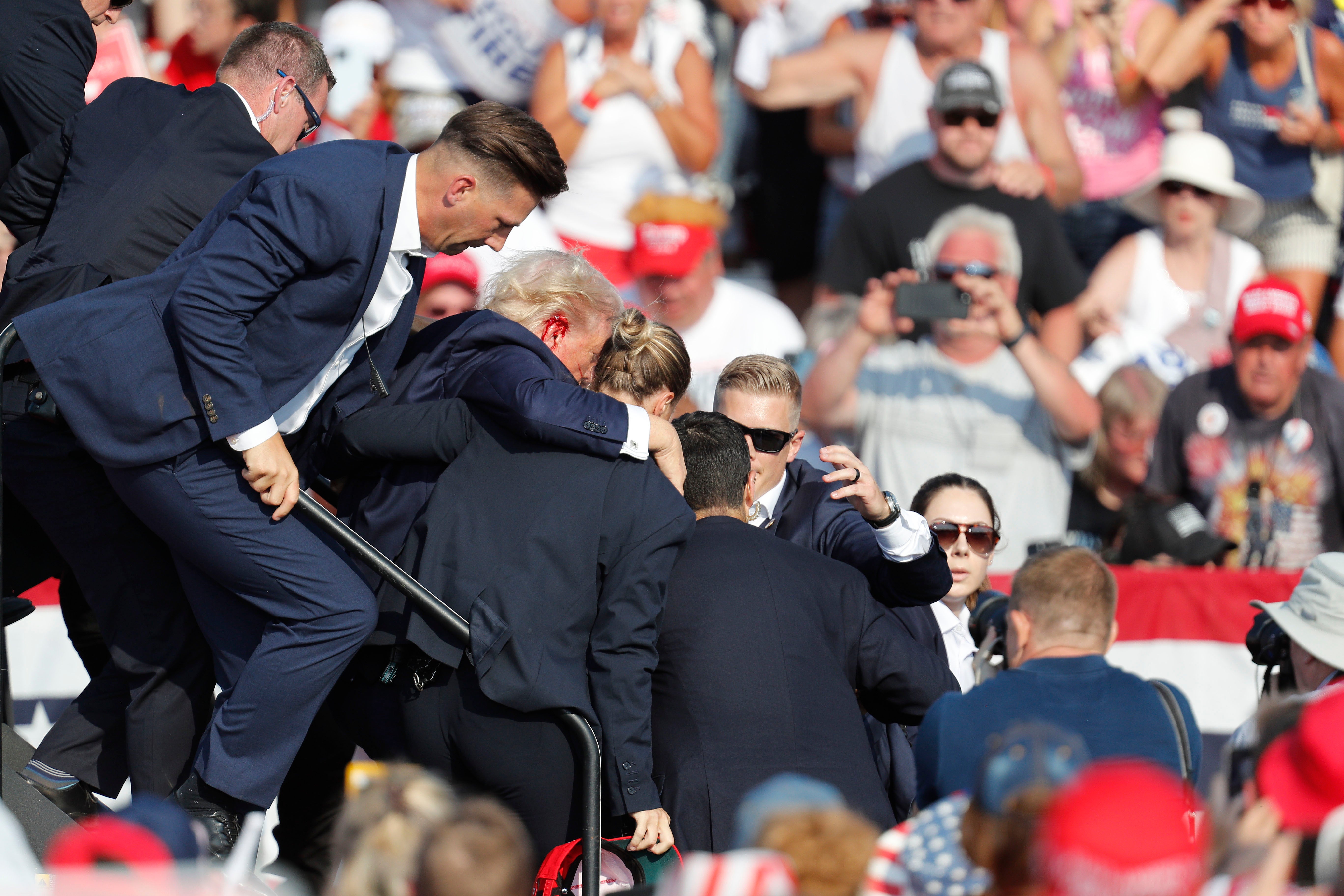 Trump is rushed off stage by Secret Service agents after the shooting