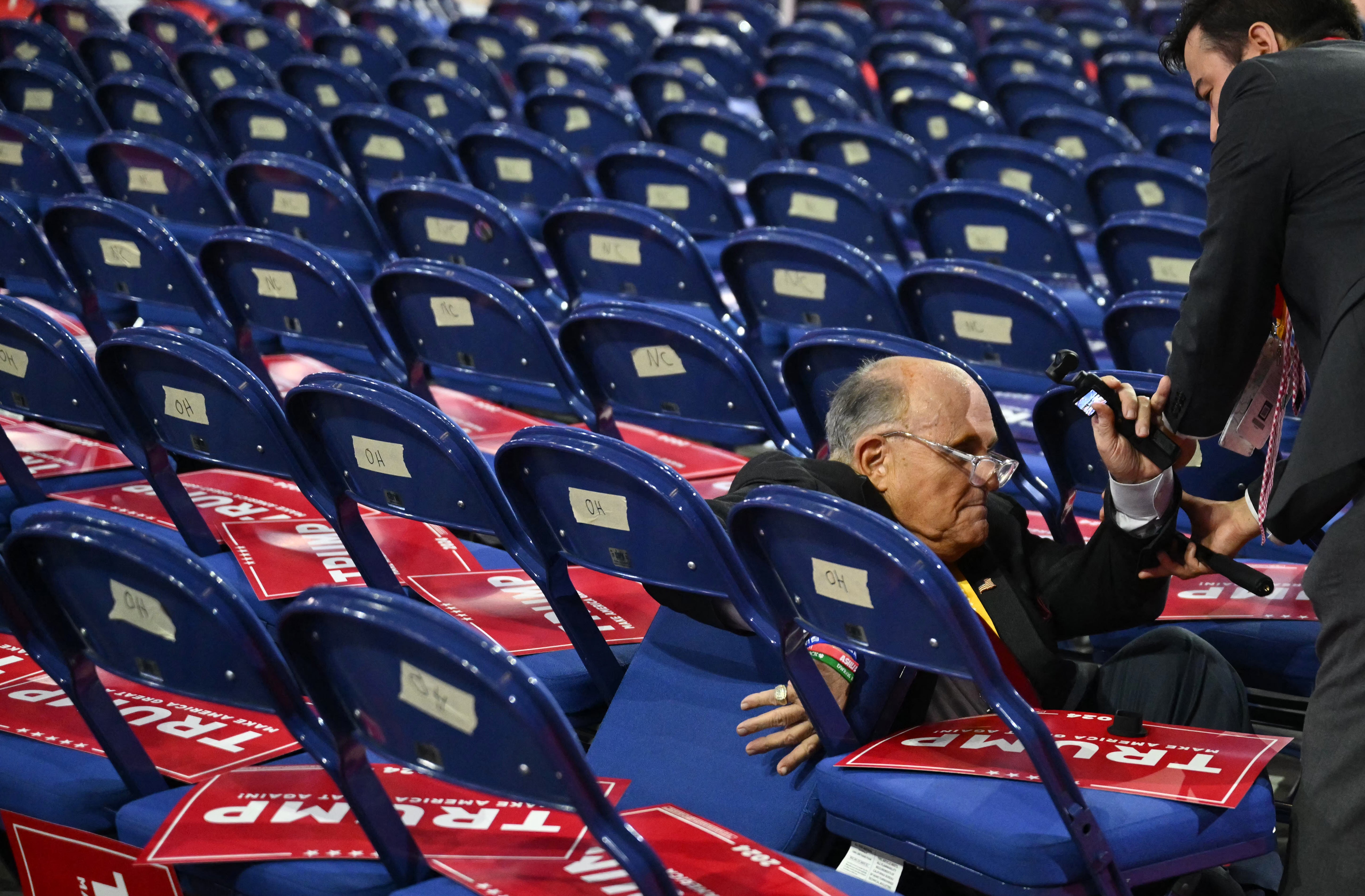 Giuliani pictured falling onto chairs at the Republican National Convention