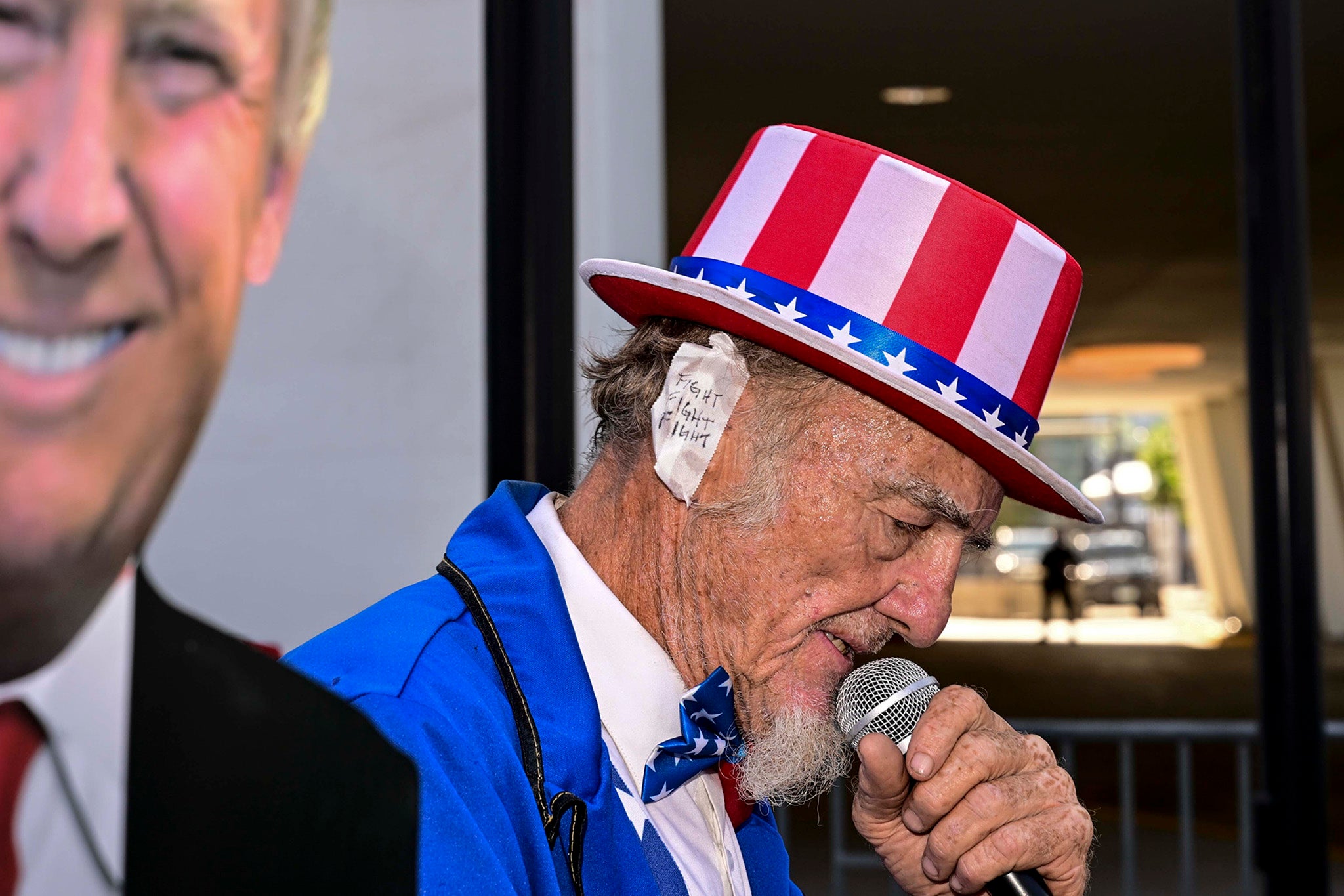 A street performer dressed as Uncle Sam wears a bandage marked ‘fight, fight, fight’