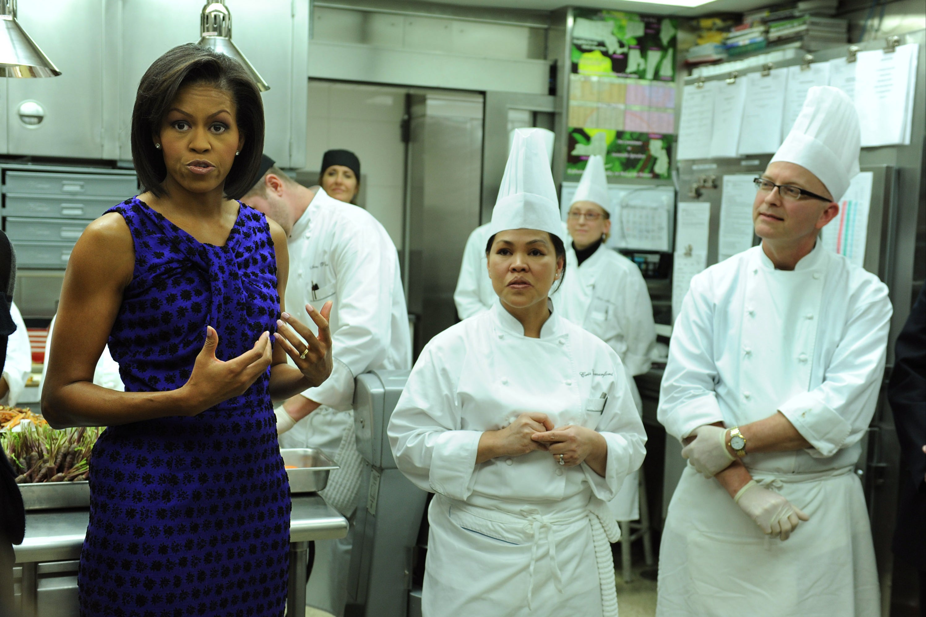 Former First Lady Michelle Obama (left) talks alongside White House Head Chef Cristeta Comerford (center) and pastry chef Bill Yosses (right)