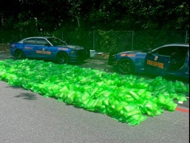 Two police cars sit parked by a load of seized methamphetamine found at the Atlanta State Farmers Market on August 8, 2024.