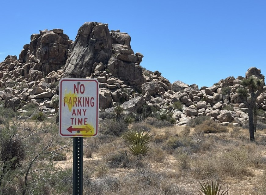 A road sign vandalized with yellow paint in Joshua Tree National Park. Three German tourists were cited for firing paintballs throughout the park and could face jail time