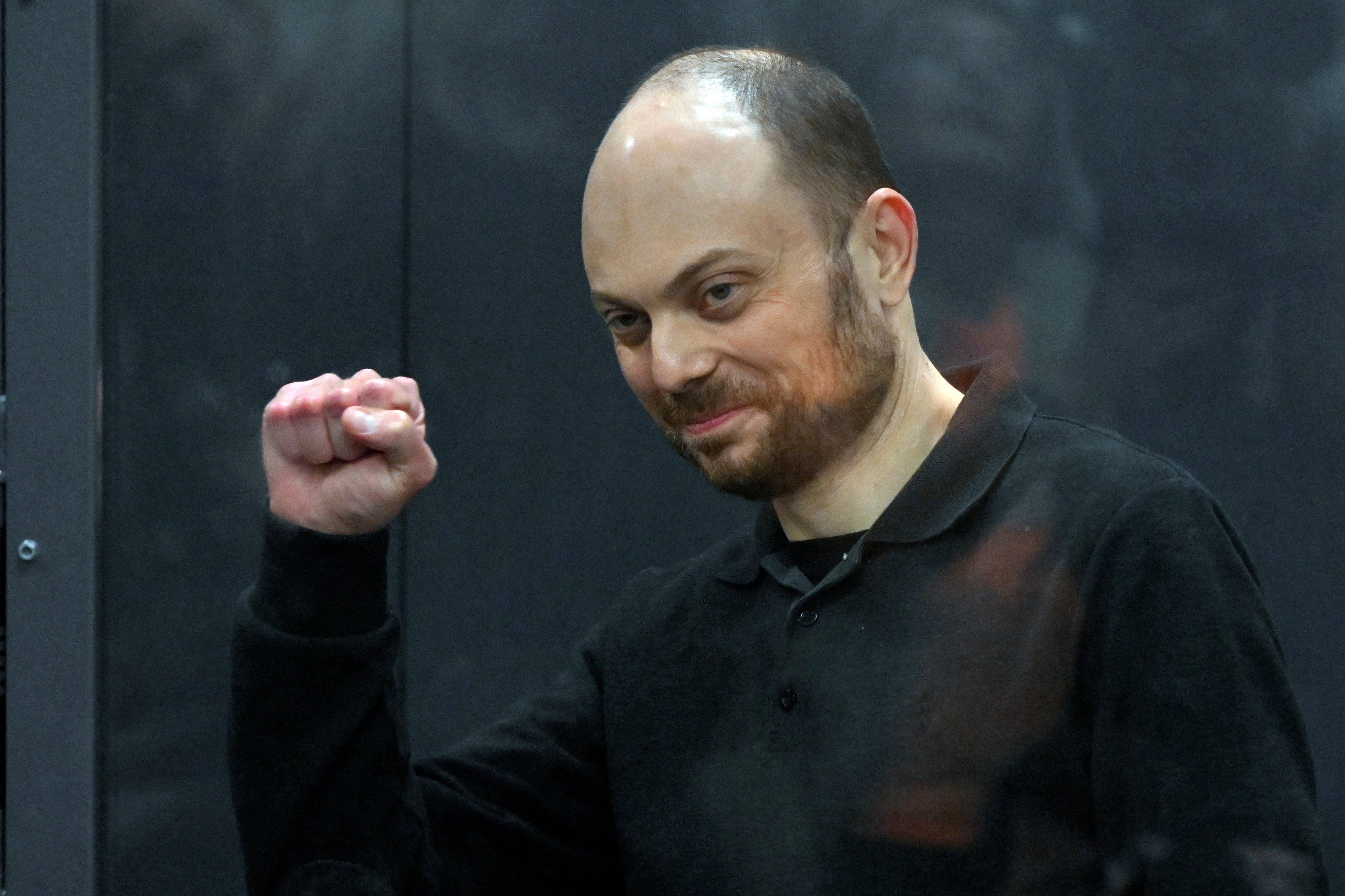 Russian opposition activist Vladimir Kara-Murza gestures standing in a glass cage in a courtroom in Moscow last year