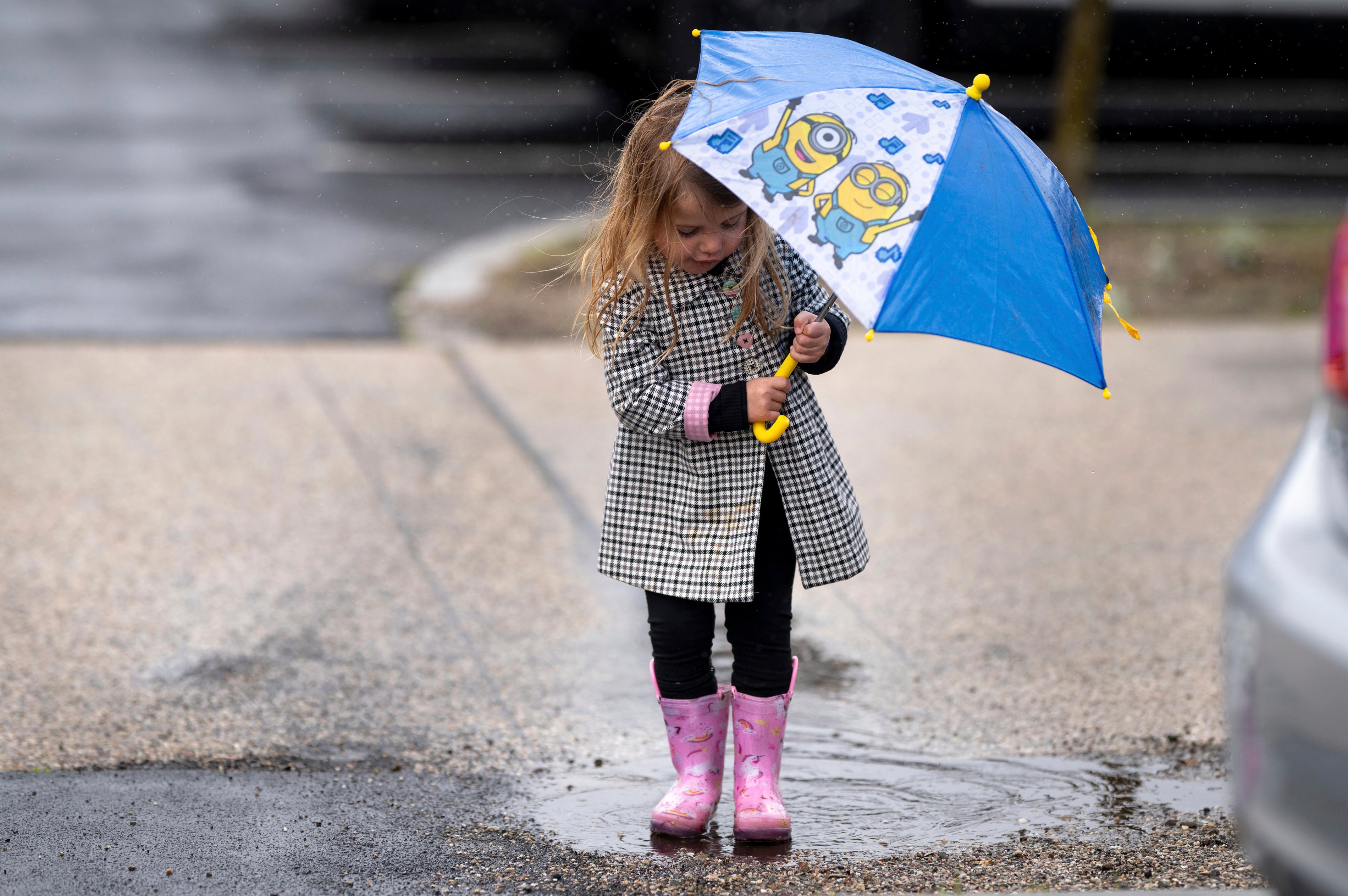 Kennedy Shoemaker, 2, of Simi Valley, tries out her rain gear on a puddle at the Ronald Reagan Presidential Library in California on February 19, 2024. The Farmers’ Almanac predicts a a wet winter in 2024-2025 for much of the US.