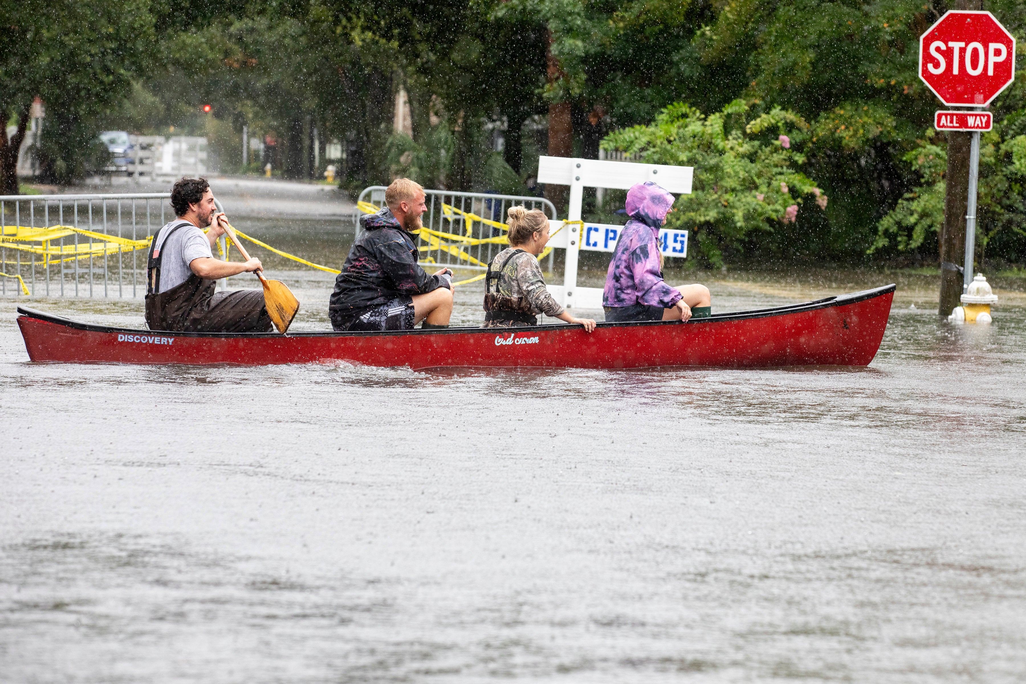 Four people paddle down a flooded street in Charleston, South Carolina as Tropical Storm Debby hit the region on Tuesday