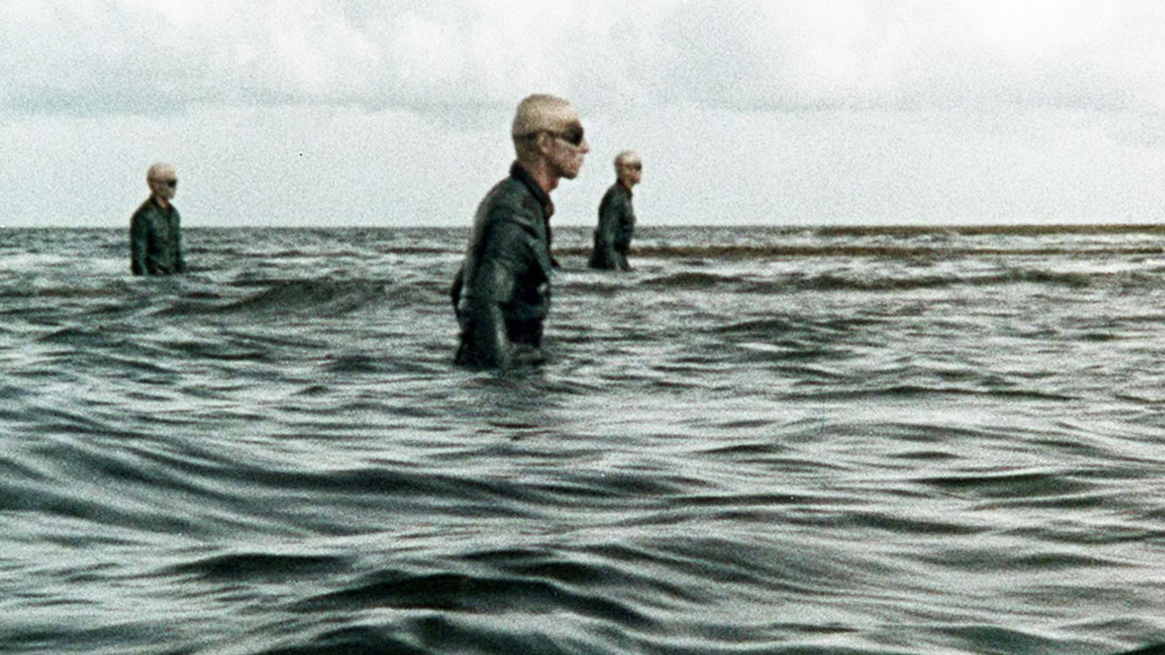 Three undead Nazi soldiers wearing dark uniforms and goggles emerge from the ocean in the 1977 horror movie Shock Waves.